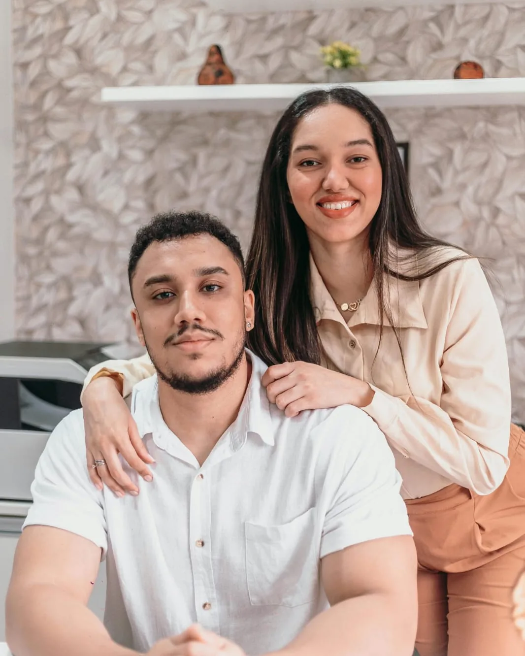 Ellen e Victor, psicólogos e fundadores da Casa Neuro, sorrindo em seu consultório